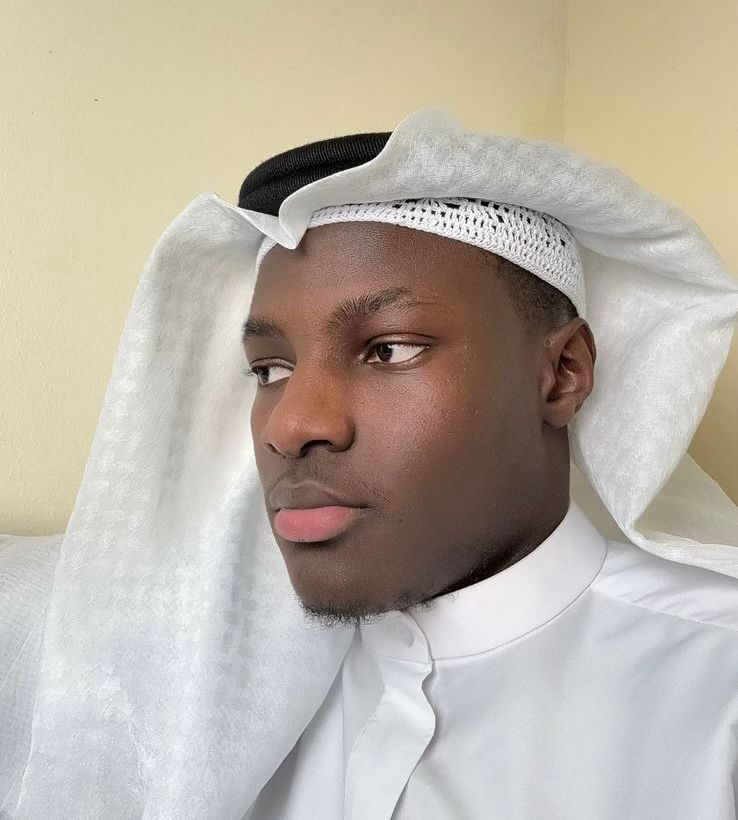 Portrait of Ibrahim Mbye, Hafiz and Madinah graduate, wearing a white kufi and ghutra